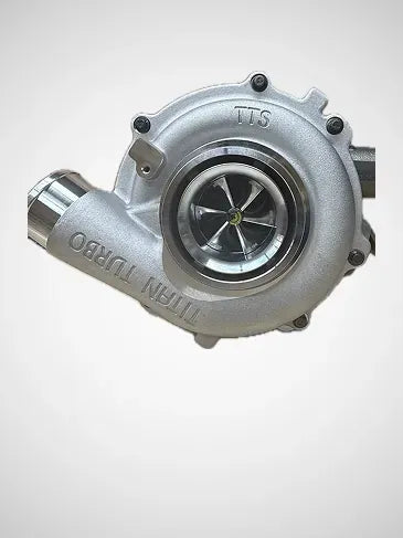 A silver metallic automotive turbocharger with visible internal turbine blades and embossed text reading 'TITAN TURBO' and 'TTS' on a plain light background.