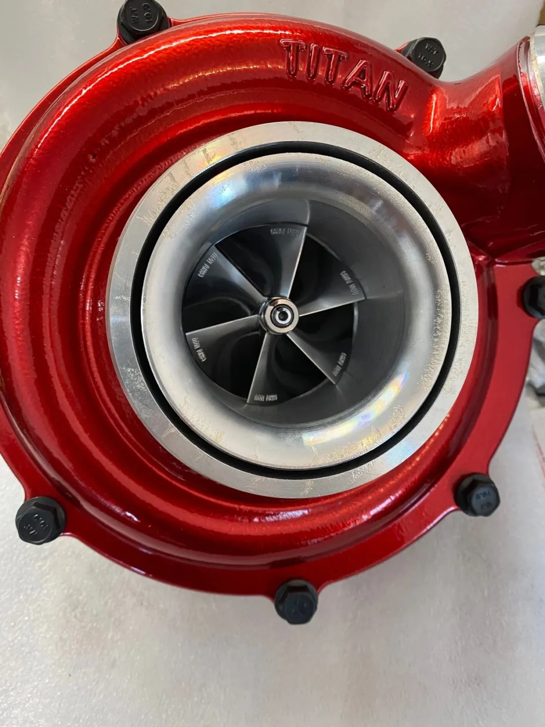 Close-up of a red turbocharger compressor wheel.